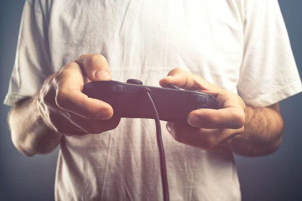 Mann benutzt Spielkonsole, um Videospiele zu spielen — Stockfoto