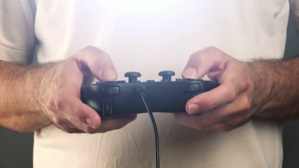 Uomo che utilizza il controller pad di gioco per giocare ai videogiochi — Video Stock