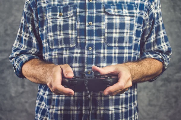 Spieler im karierten Hemd spielt Videospiel mit Gamepad — Stockfoto