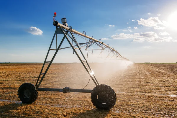 Agrarische irrigatie op geoogste tarwe stoppels veld — Stockfoto