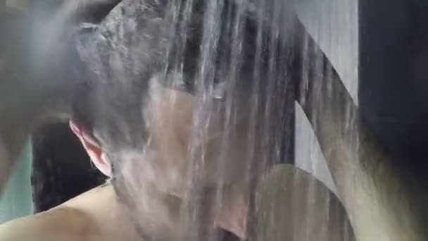 Mann wäscht Haare unter der Dusche — Stockvideo