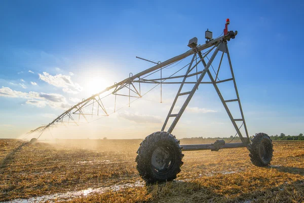 Agrarische irrigatie op geoogste tarwe stoppels veld — Stockfoto