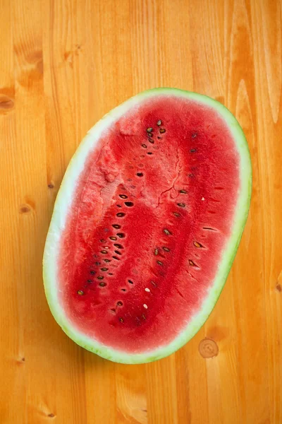 Watermelon cross section slice on wooden table — Stock Photo, Image