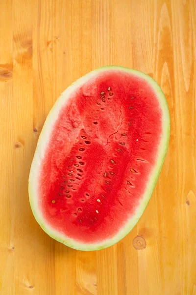 Watermelon cross section slice on wooden table — Stock Photo, Image