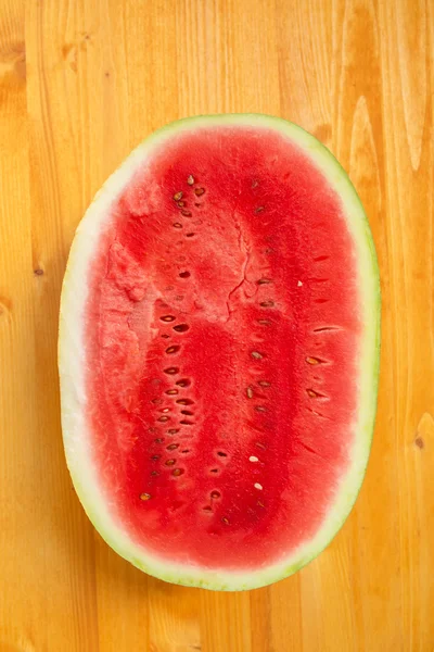 Watermelon cross section slice on wooden table — Stock Photo, Image