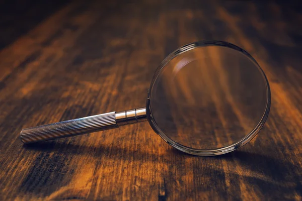 Loupe vergrootglas op houten bureau — Stockfoto