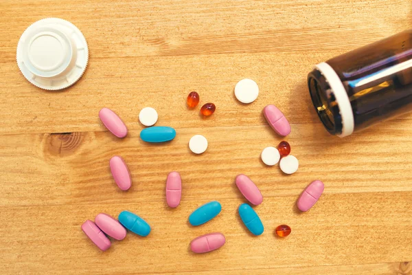 Bunte medizinische Tabletten und Pillen auf dem Schreibtisch — Stockfoto