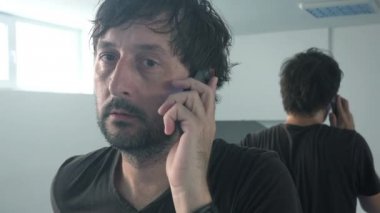 Casual adam cep telefonu ayna önünde konuşurken