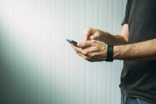 Casual man met behulp van slimme telefoon tekstbericht te sturen — Stockfoto