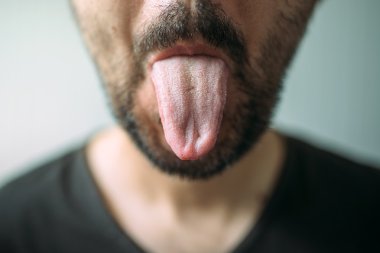 Dil yapışkanlık dışarı yetişkin tıraşsız adam