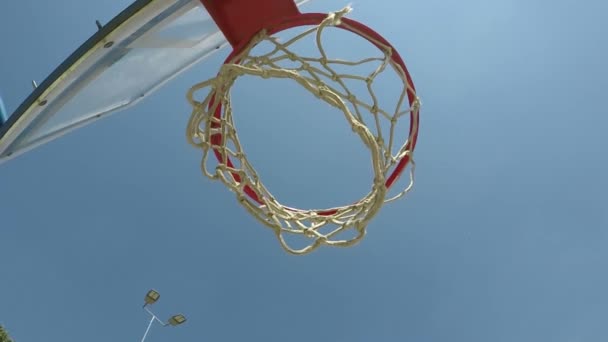 Мяч падает через баскетбольное кольцо — стоковое видео