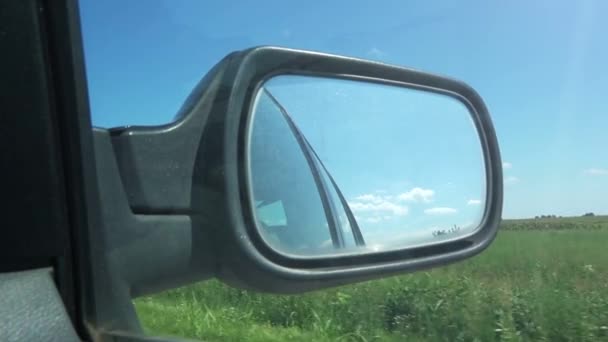 Проезд по сельской местности, вид из бокового зеркала автомобиля — стоковое видео