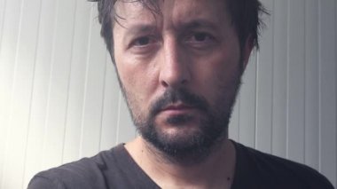 Ciddi yetişkin adam kameraya bakan