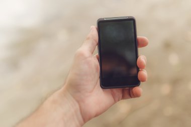 Erkek el ile hareket eden telefon sahilde