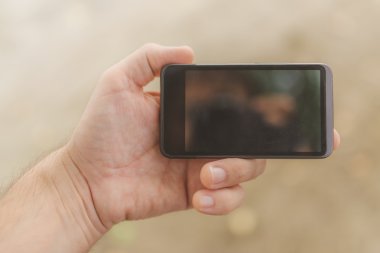 Erkek el ile hareket eden telefon sahilde