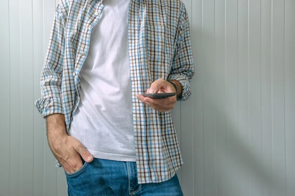 Entediado homem casual usando telefone celular — Fotografia de Stock