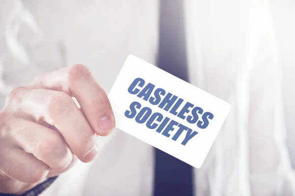 Empresário segurando cartão com título da sociedade Cashless — Fotografia de Stock