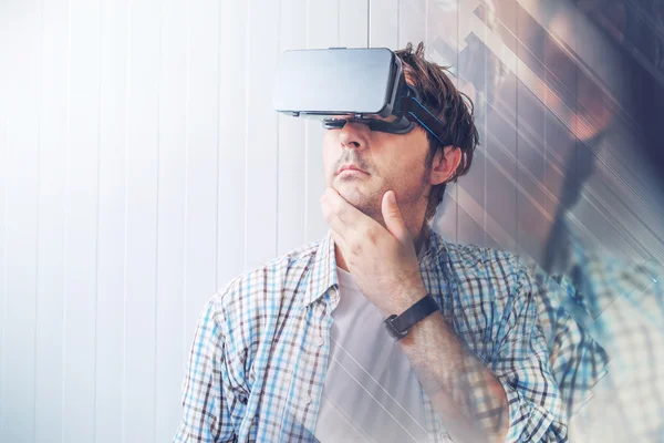 Человек в очках виртуальной реальности исследует содержимое виртуальной реальности — стоковое фото