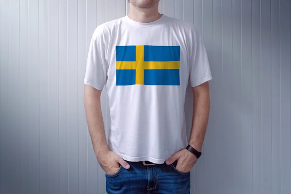 Hezký příležitostný muž na sobě bílé tričko s švédská vlajka — Stock fotografie