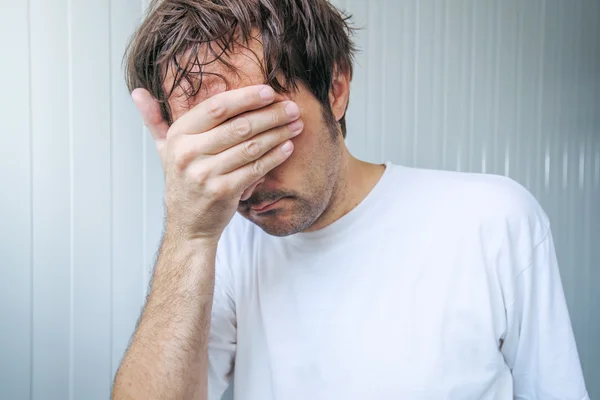 Trauriger und blauer Mann bedeckt Gesicht und weint — Stockfoto