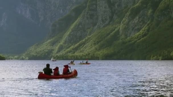 Люди катаются на байдарках по Словенскому озеру Бохинь — стоковое видео