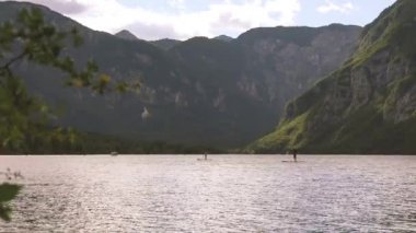 Tahta kürek tanınmayan insanlar Bohinj Gölü üzerinde ayağa