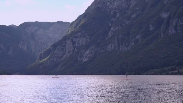 Oigenkännlig personer paddla ombordstigning på lake Bohinj — Stockvideo