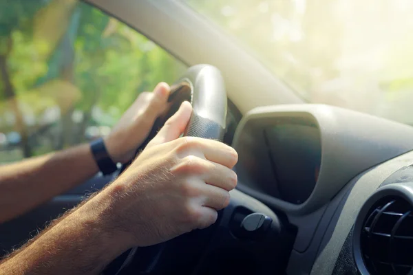 Мужские руки держат руль автомобиля — стоковое фото