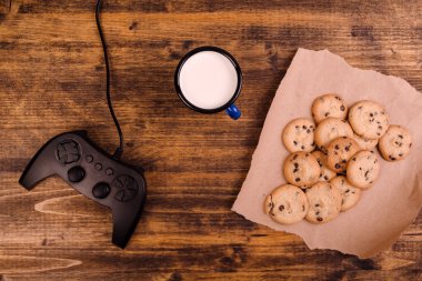 Gamepad ve ev yapımı çikolatalı kurabiye rustik ahşap sekmesinde