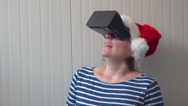 Kobieta z Boże Narodzenie Santa Claus kapelusz i Vr headset — Wideo stockowe