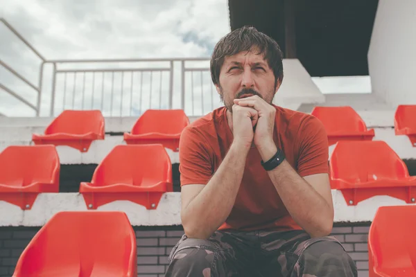 Besviken man på idrottsstadion tittar på spelet — Stockfoto