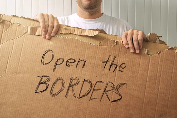 Uprchlíka držící lepenky s otevřeným hranice požadavku — Stock fotografie