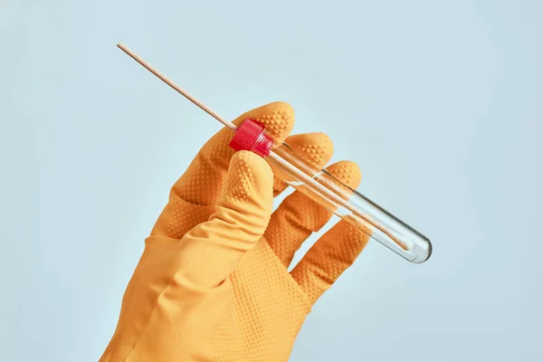 Laboratory technician holding sterile oral mouth swab in tube, used for novel coronavirus testing