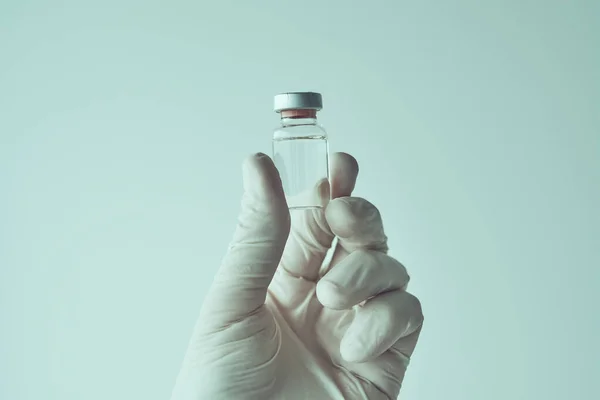 持有Covid 19疫苗接种概念疫苗瓶的医生 手拉手 有选择地集中注意 — 图库照片