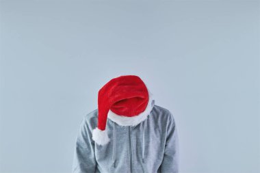Üzgün ve üzgün bir adam, Noel Baba şapkasıyla aşağı bakıyor, fotokopi alanı olan bir resim.