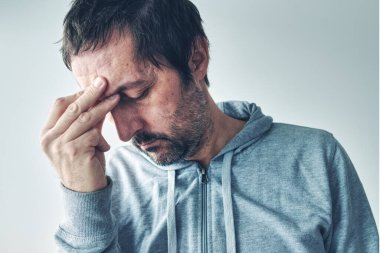 Akşamdan kalma baş ağrısı, sabahları alkol aldıktan sonra alnında şiddetli ağrı çeken bir adam.