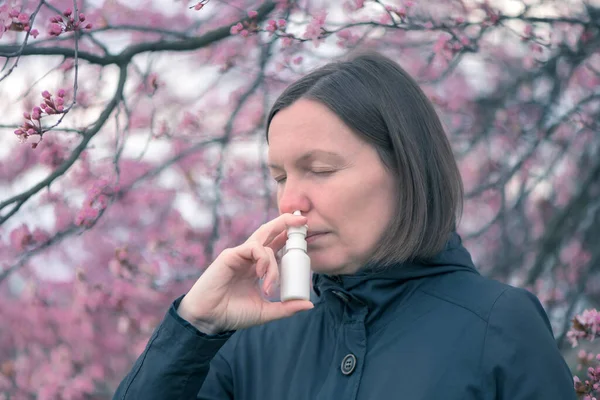 花粉症治療のために屋外で鼻スプレーを使用する女性 — ストック写真