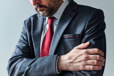 Kollarını kavrayan, kendine güveni olmayan işadamı kötü haberleri bekliyor, çapraz kollar duruşu vücut dili, seçici odaklanma.