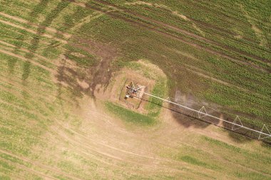 Merkez pivot sulama ekipmanlarının hava görüntüsü çiftlik çiftliğindeki yeşil soya tohumlarını suluyor, insansız hava aracı pov görüntüleri...