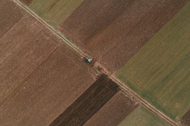 Tarlada çiftçilik yapan iki traktörün hava görüntüsü, İHA pov yüksek açılı görüntüsü
