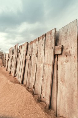 Worn wooden fence on sandy beach, vertical image selective focus