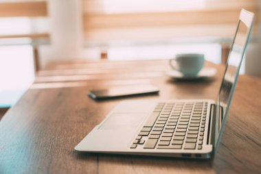 Ev ofis çalışma alanı, dizüstü bilgisayar ve akıllı telefon ev konsepti ve seçici odak çalışma masasında.