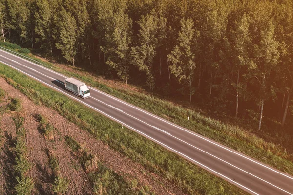 夏季下午 卡车在公路上穿越绿林景观的空中景观 无人飞机拍摄的高角镜头 — 图库照片