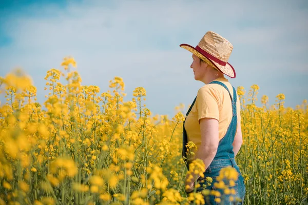 Achteraanzicht Van Vrouwelijke Landbouwer Die Bloeiende Koolzaadplantages Gewassen Horizon Kijkt — Stockfoto