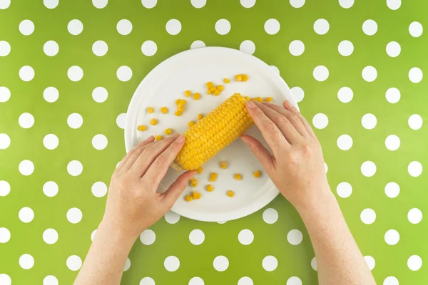 Woman eating maize corn, top view — Stock Photo, Image