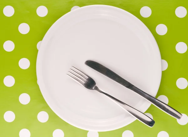 Пустая белая плоская тарелка с вилкой и ножом — стоковое фото