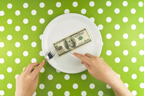 Mujer comiendo billete de cien dólares para la cena — Foto de Stock