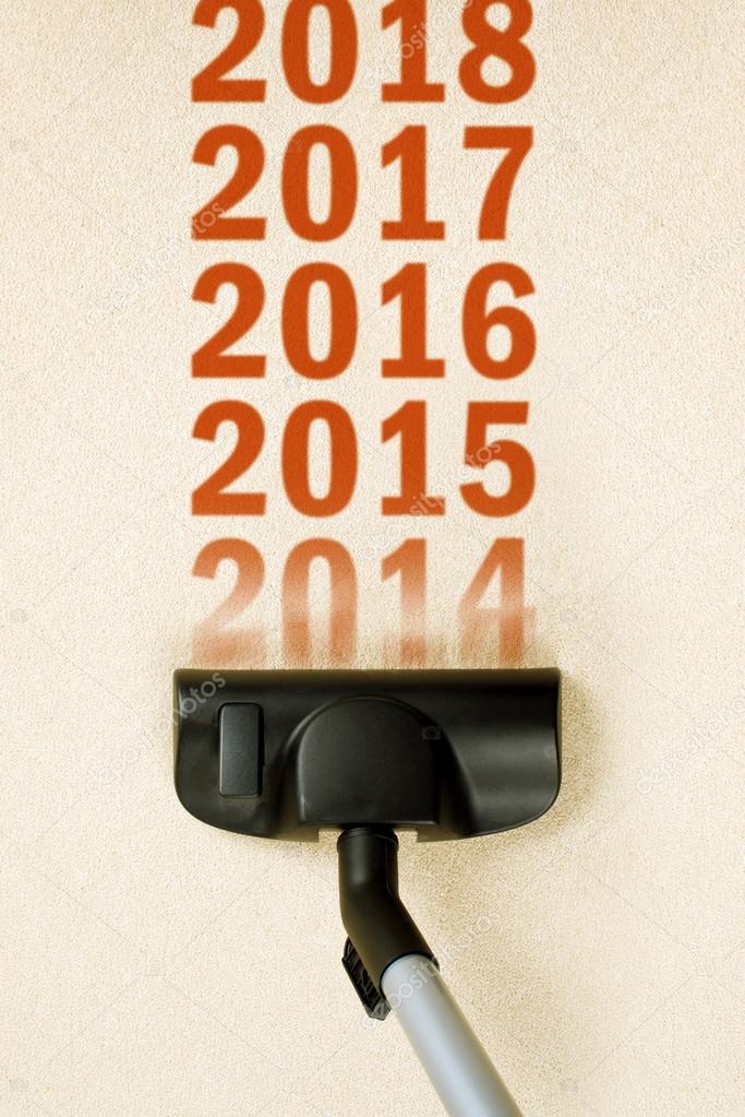 Vacuum Cleaner sweeping year number 2014 from carpet