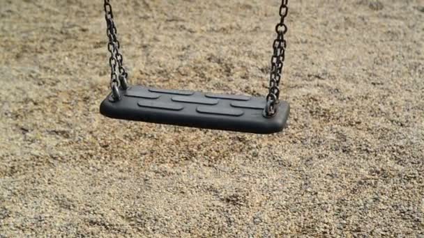 Empty swing seat swaying at playground in the park. — Stock Video