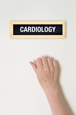 Female hand is knocking on Cardiology door clipart